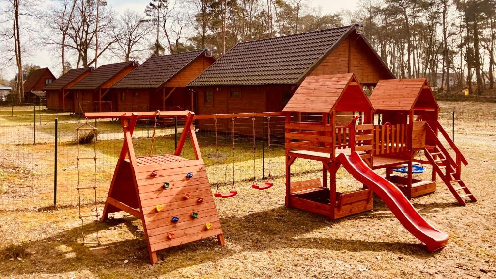 a playground with a slide and a play house at Jantar Oaza in Jantar