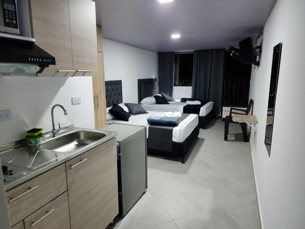 uma cozinha e uma sala de estar com uma cama e um sofá em Aparta estudios Estadio la 80 em Medellín