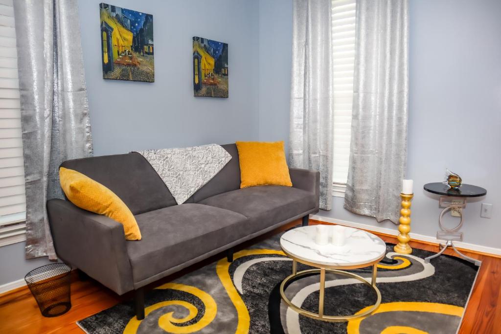 a living room with a couch and a table at Cozy 2BR Apartment, Balcony with City Skyline View, Mardi Gras Park, Free Parking, Wi-Fi in Mobile
