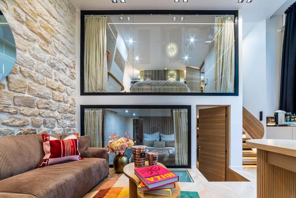 un salon avec un canapé et un mur en pierre dans l'établissement B Luxe Triplex, Cinema Near Place des Vosges AC, à Paris