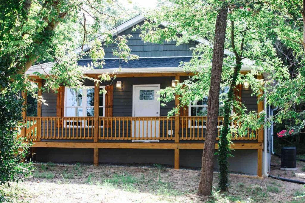 a log cabin with a large deck with trees at Farmville Modern Farmhouse in Farmville