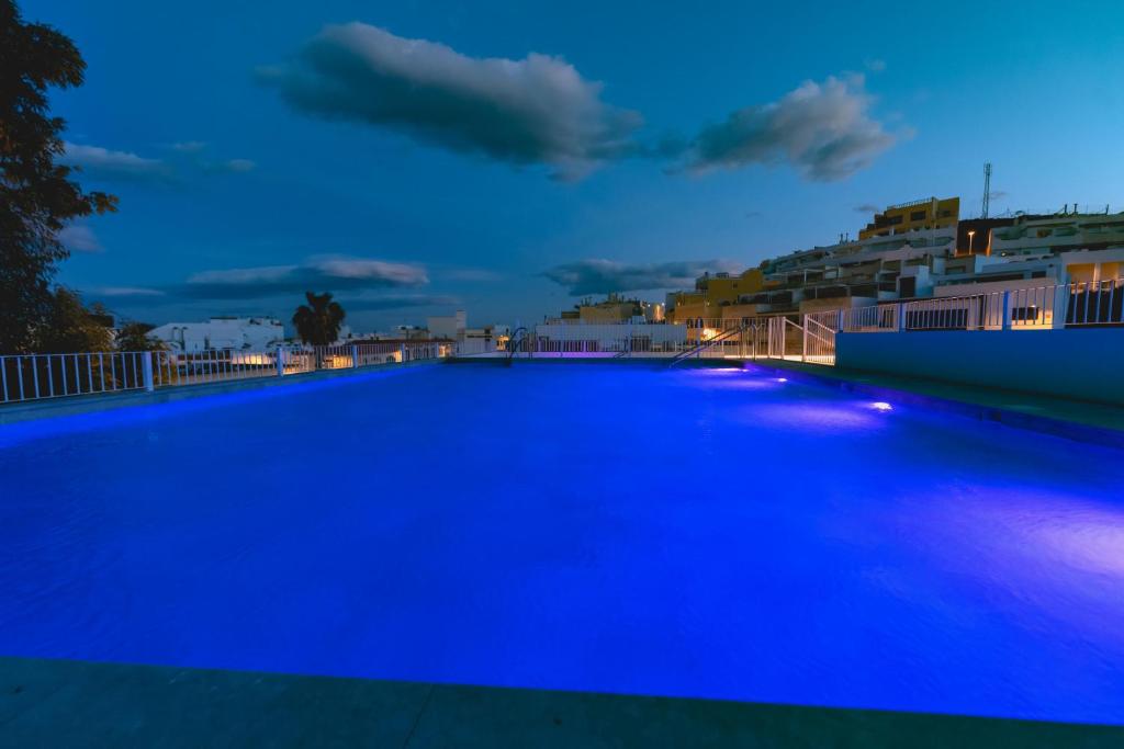 a large swimming pool with blue lighting at night at HOTEL ALOVE in San José
