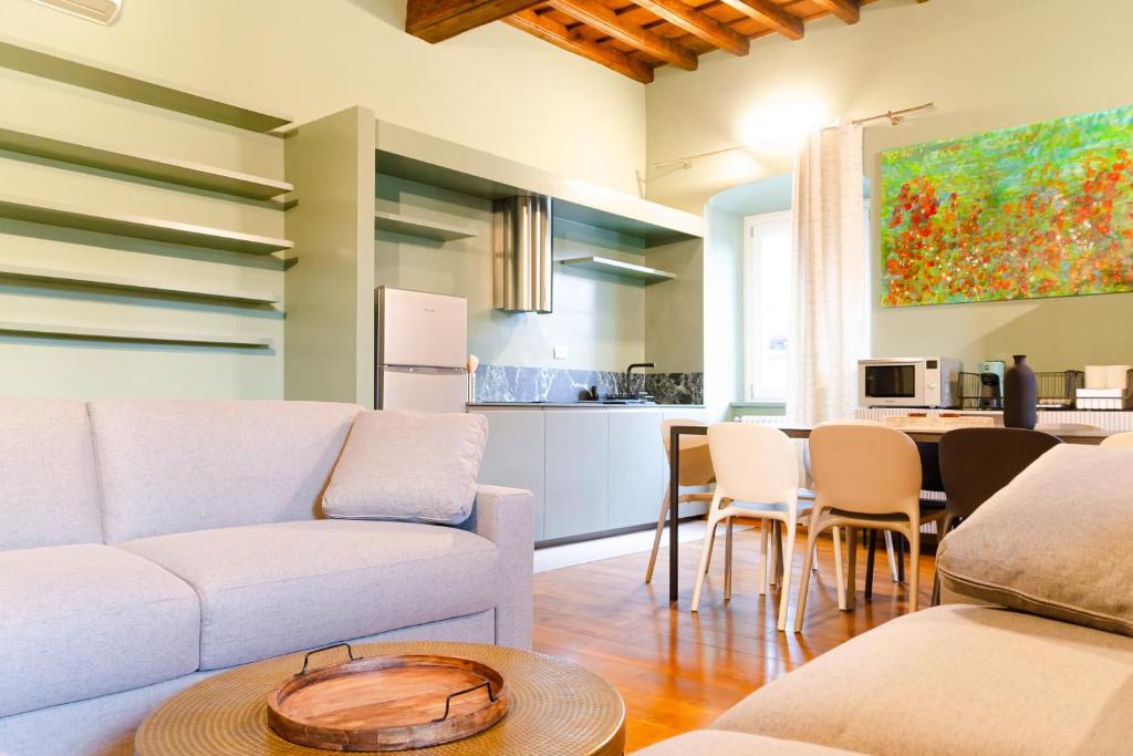 een woonkamer met een bank en een tafel bij La sosta verde by HAPPYHOSTORINO in Turijn