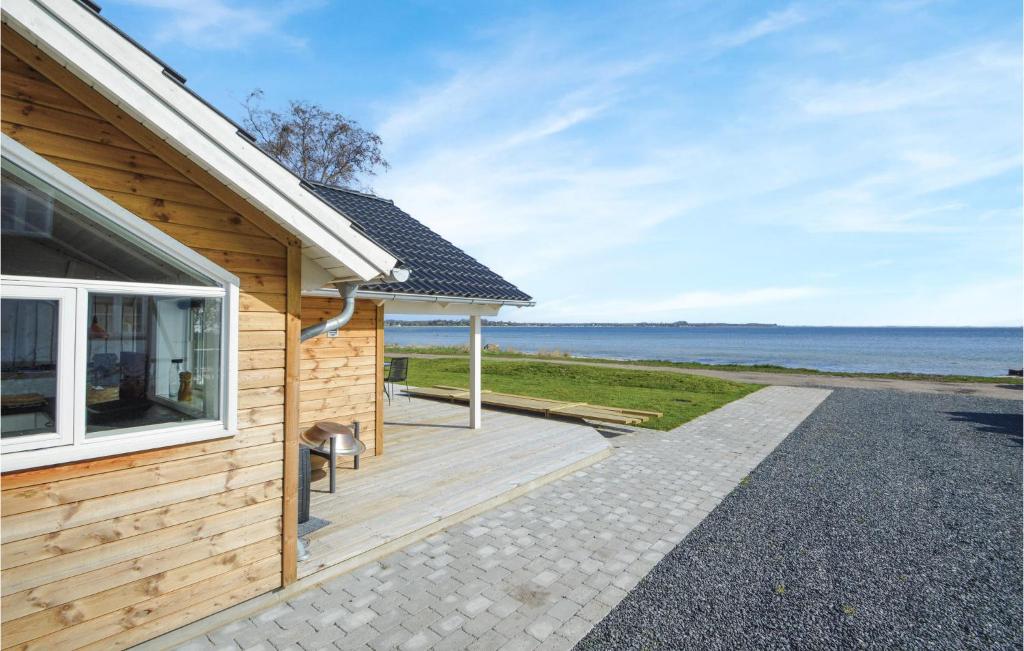 Casa de madera con porche junto al océano en Amazing Home In Sjlund With Kitchen, en Sjølund
