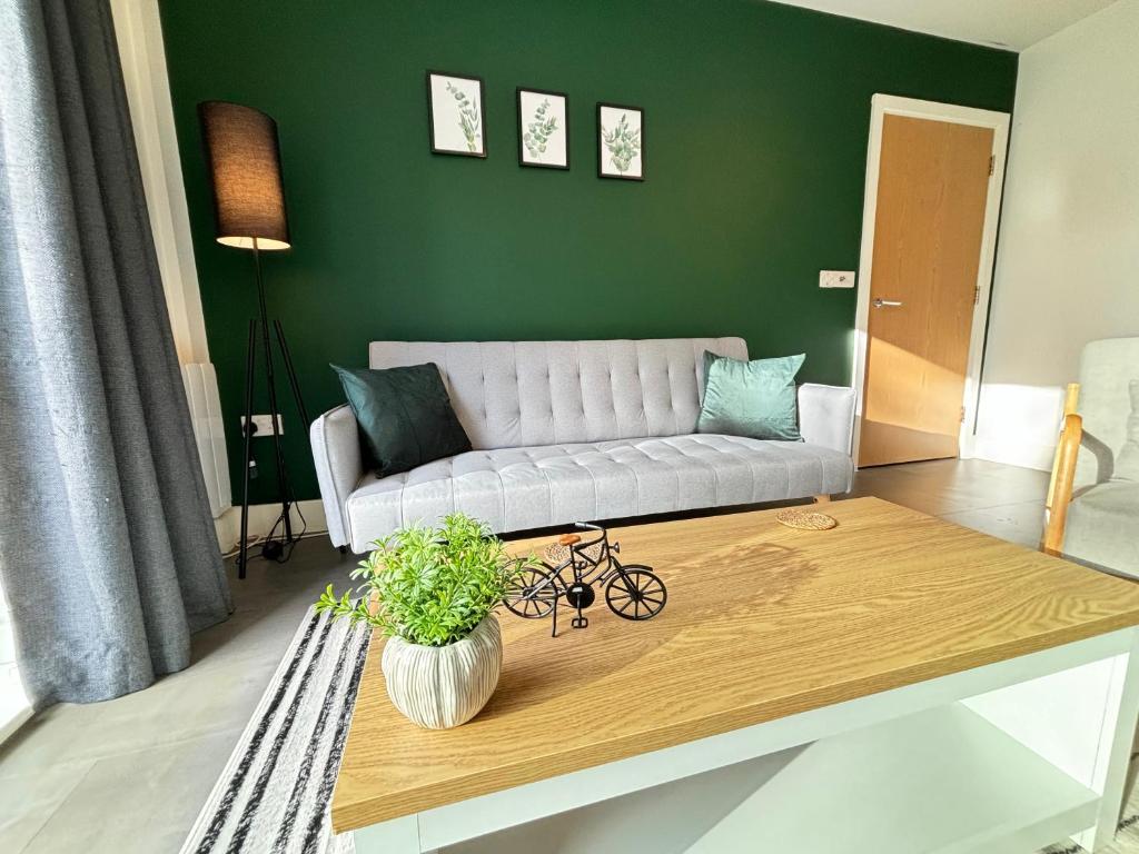赫默爾亨普斯特德的住宿－Luxury Canal-side Apartment, Hemel Hempstead, Free parking, Perfect for Contractors，带沙发的客厅和咖啡桌上的自行车
