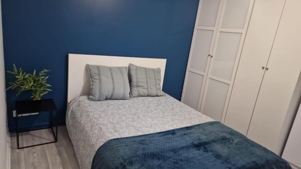a blue room with a bed with two pillows at Joli appart à 10mn de paris in Bezons