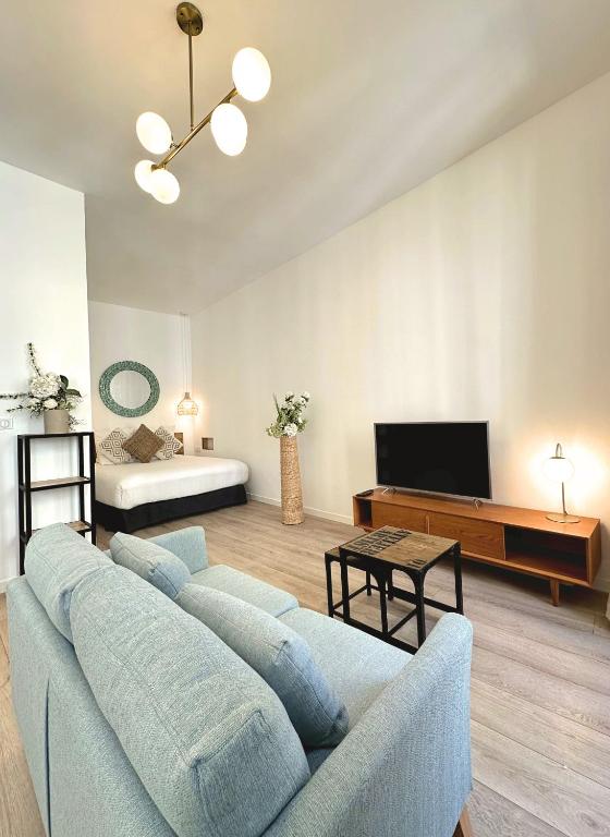 a living room with a blue couch and a bed at Les Appartements du Vieux Port in Marseille