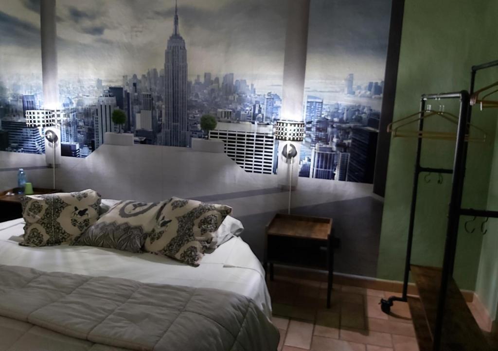 a bedroom with a bed with a city mural on the wall at I Portici guest house in Alessandria