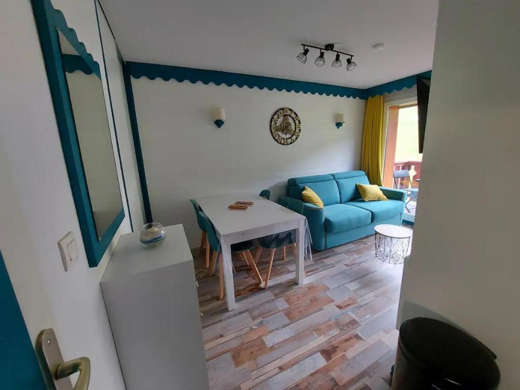 a living room with a blue couch and a table at Appartement 6 personnes in Saint-François-Longchamp