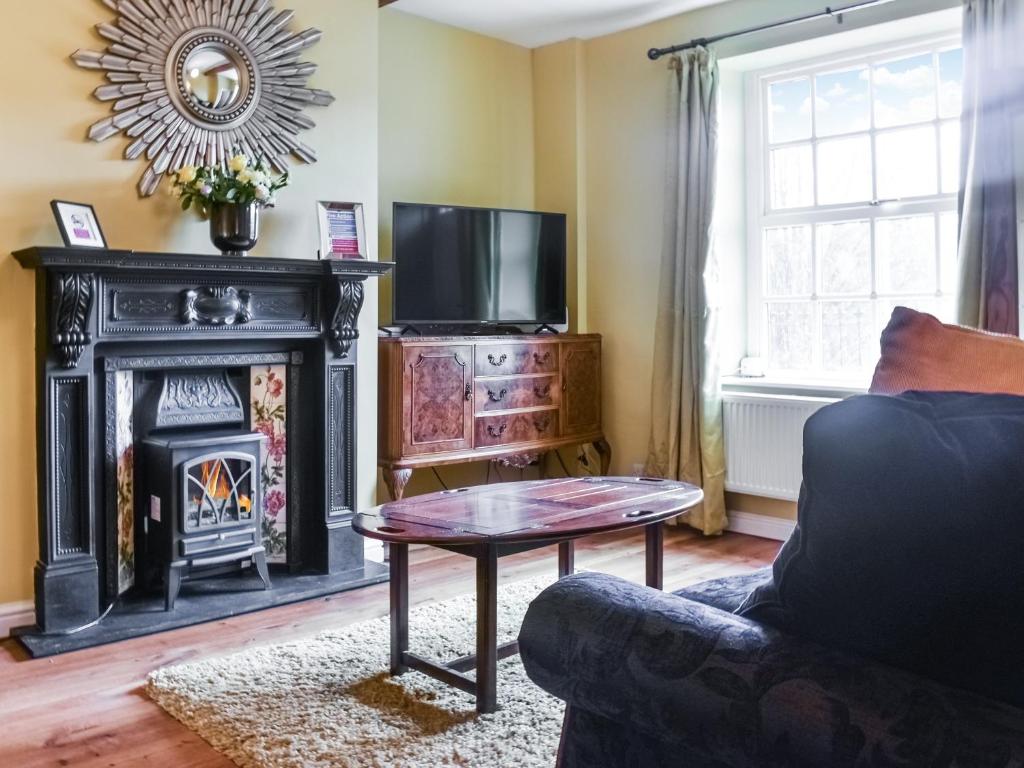 sala de estar con chimenea y TV en Vintage Cottage, en Luddenden Foot