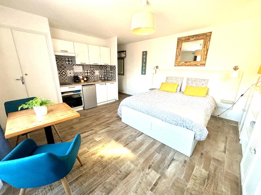 1 dormitorio con 1 cama, 1 mesa y 1 silla azul en Studio Centre Plage parking gratuit en Collioure