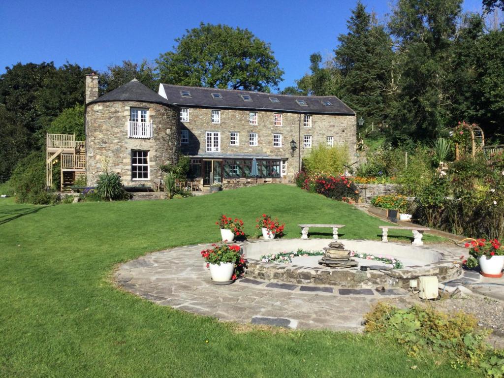 an old stone house with a fountain in the yard at The Mill House in Santon