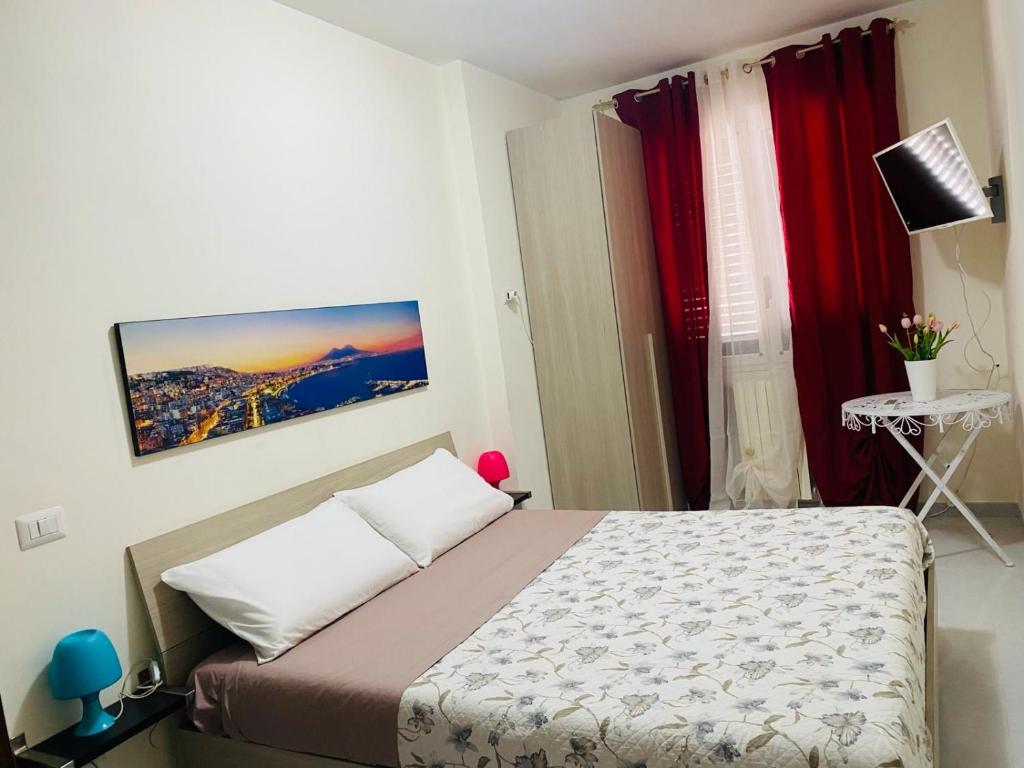 ein Schlafzimmer mit einem Bett in einem Zimmer mit roten Vorhängen in der Unterkunft B&B il Tulipano in Muro Lucano