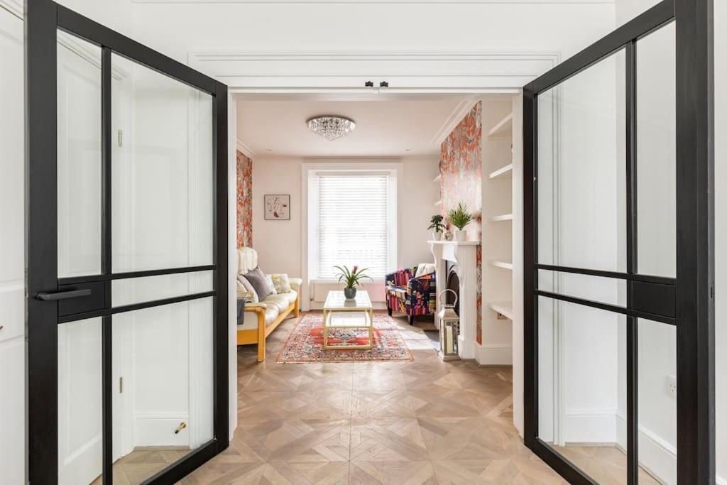 a hallway with glass doors and a living room at Historic Joseph Conrad House in Heart of London! in London