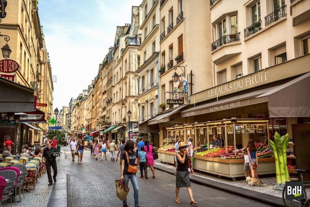 un groupe de personnes marchant dans une rue de la ville dans l'établissement Beau 3 pièces rue Poissonnière, à Paris