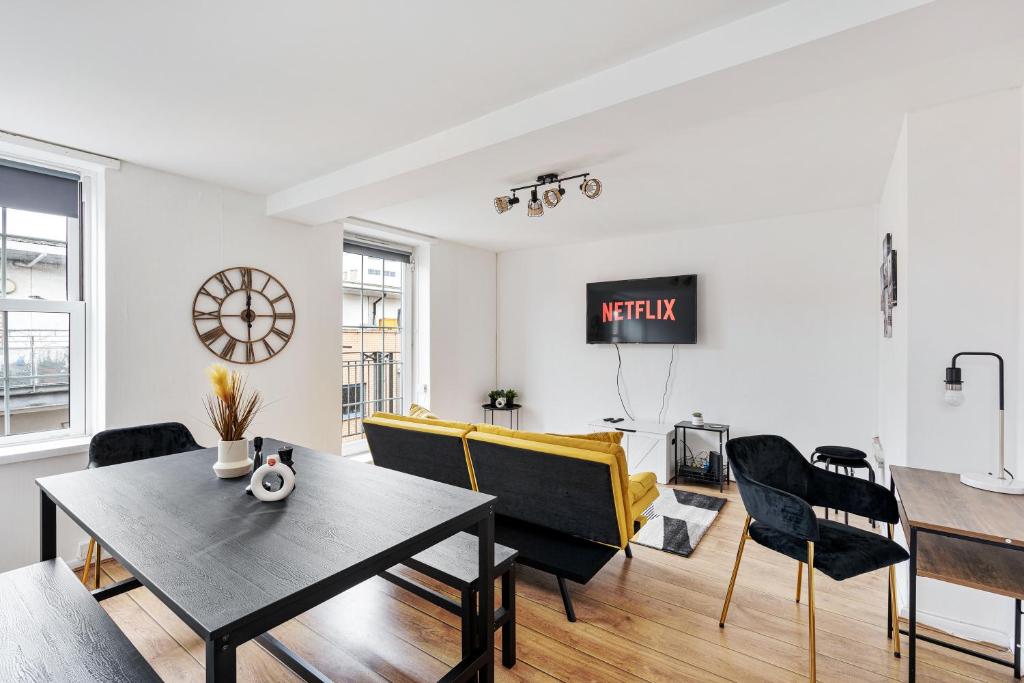 a living room with a yellow couch and a table at Sleek Shoreditch Hideout - 2 Bed Gem with Balcony in Central London in London