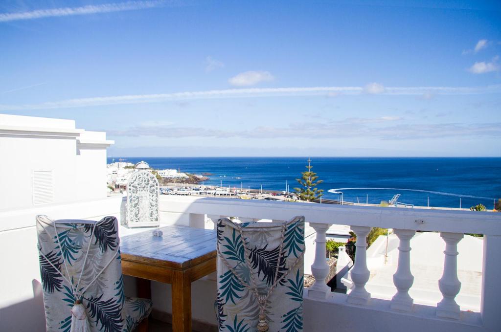 balcón con mesa y vistas al océano en Vittorio splendida vista en Tías