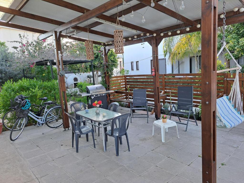 un patio con mesa, sillas y parrilla en House Near The Beach (Militsa & Aggeliki), en Perivolia