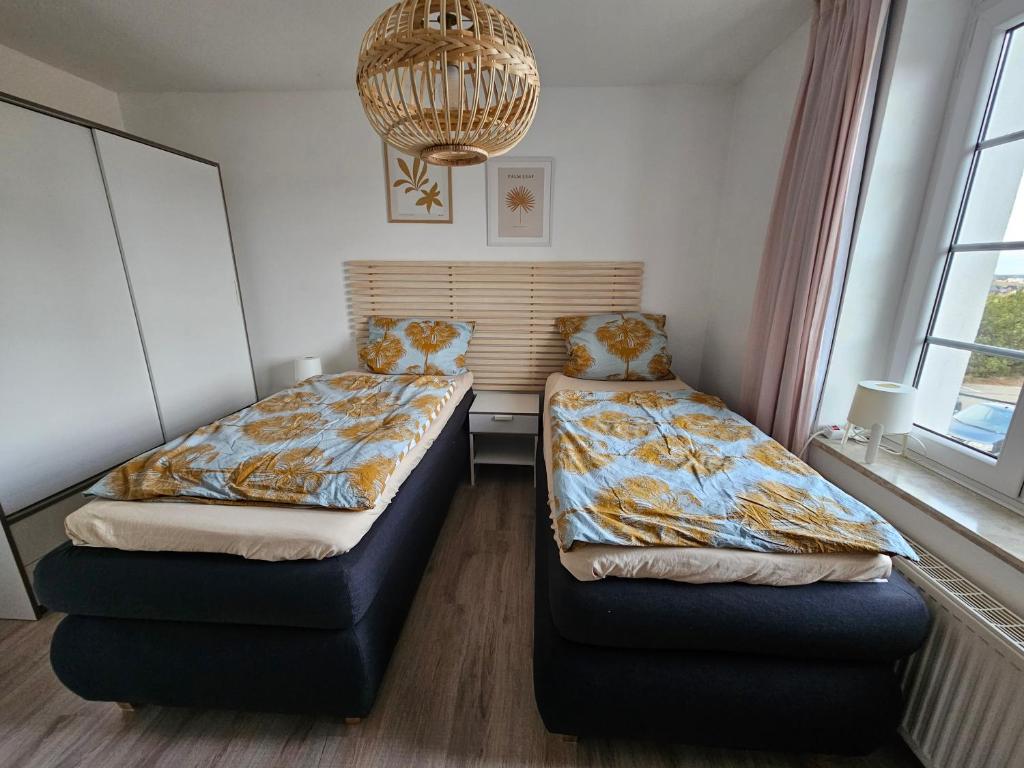 a bedroom with two beds and a couch and a chandelier at Ferienhaus in der Eifel Nähe Burg Satzvey, Phantasialand, Eifelwanderwege in Mechernich