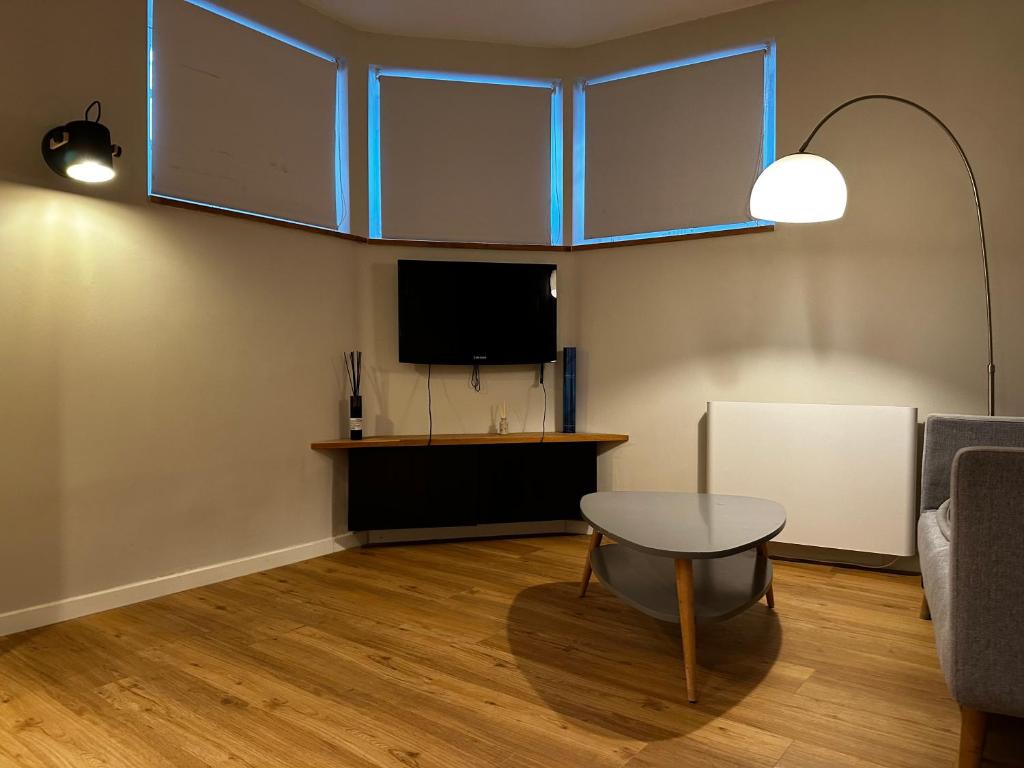 un salon avec une table et une télévision dans l'établissement Appartement au coeur de Strasbourg, à Strasbourg