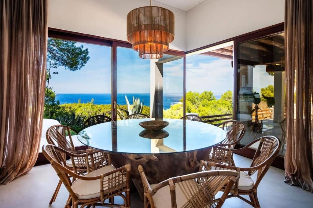 a dining room with a glass table and chairs at Sea La Vie - Stunning Sea and Jungle Views in San Antonio