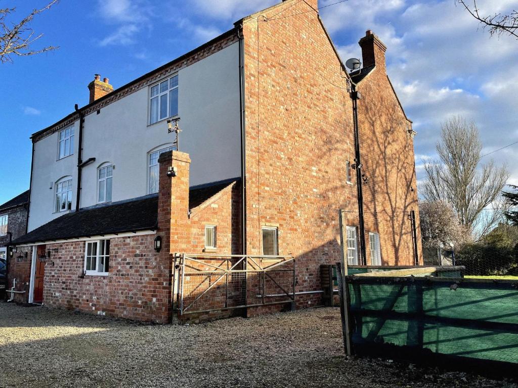 an old brick building with a large window on it at Rear of Northway Court Farm in Tewkesbury