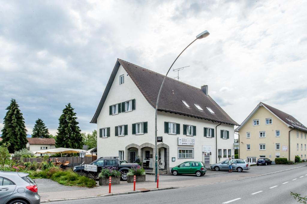 a white building with a black roof on a street at Gästehaus Brugger in Bregenz