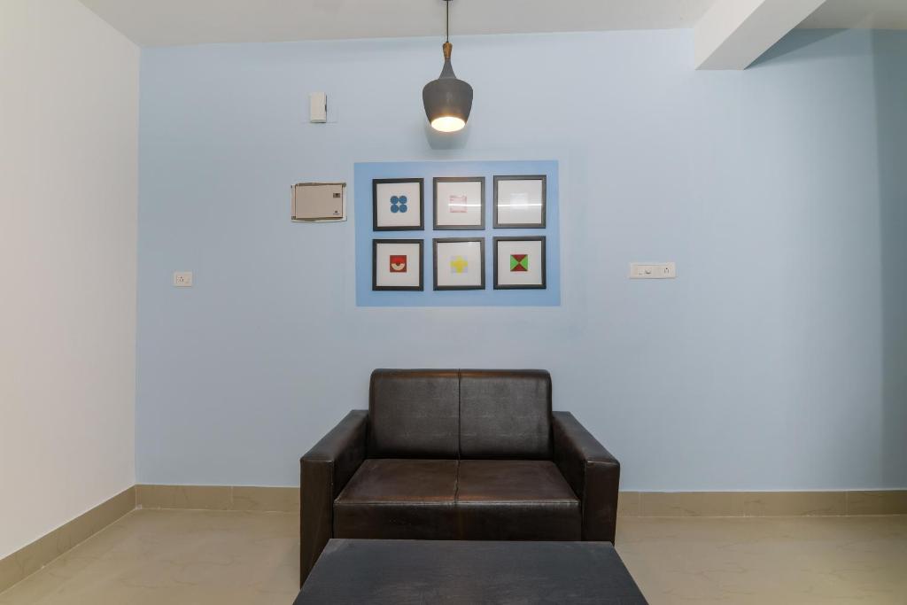 a chair in a room with a white wall at OYO Flagship Saket Homes in Bhubaneshwar
