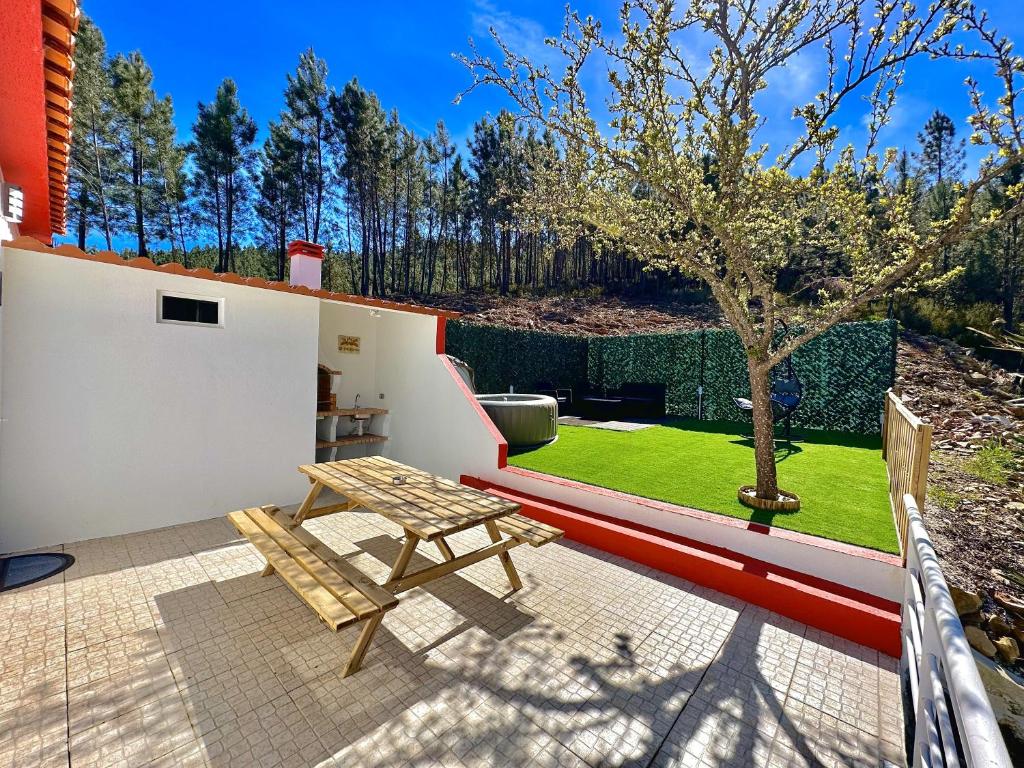 une terrasse avec un banc en bois et un arbre dans l'établissement Cantinho do Vale - Oleiros, à Oleiros
