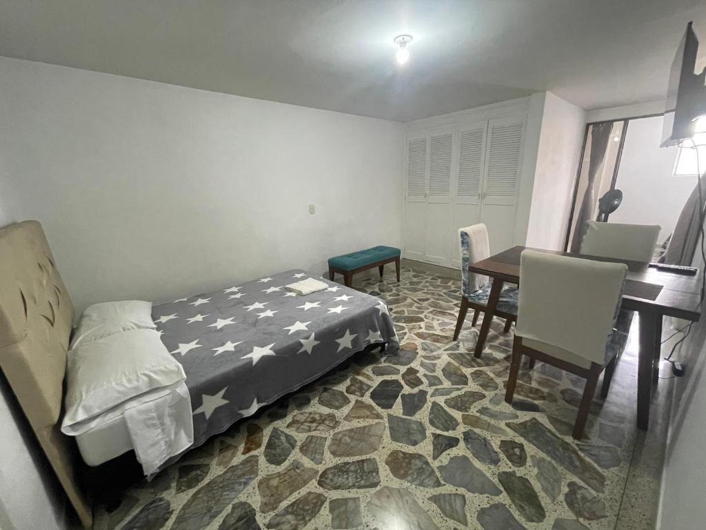 1 dormitorio con 1 cama, mesa y sillas en Apartamento cómodo , céntrico y bien ubicado Apto 301, en Medellín