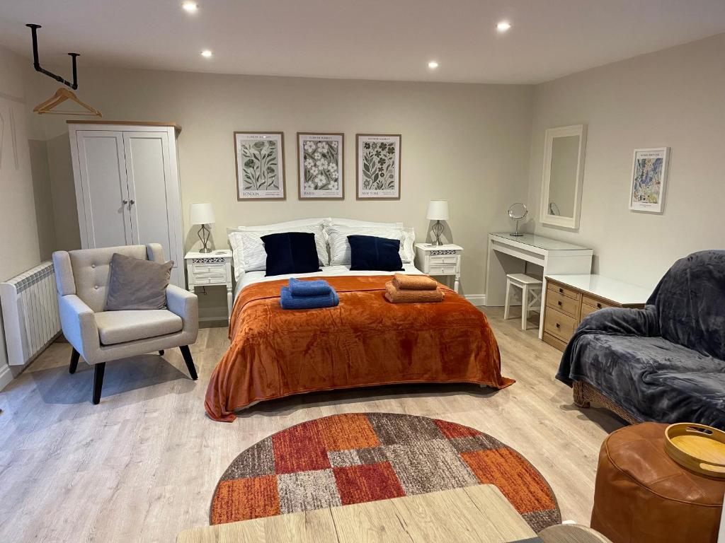 a bedroom with a bed and a couch and a chair at The Studio in Harrogate