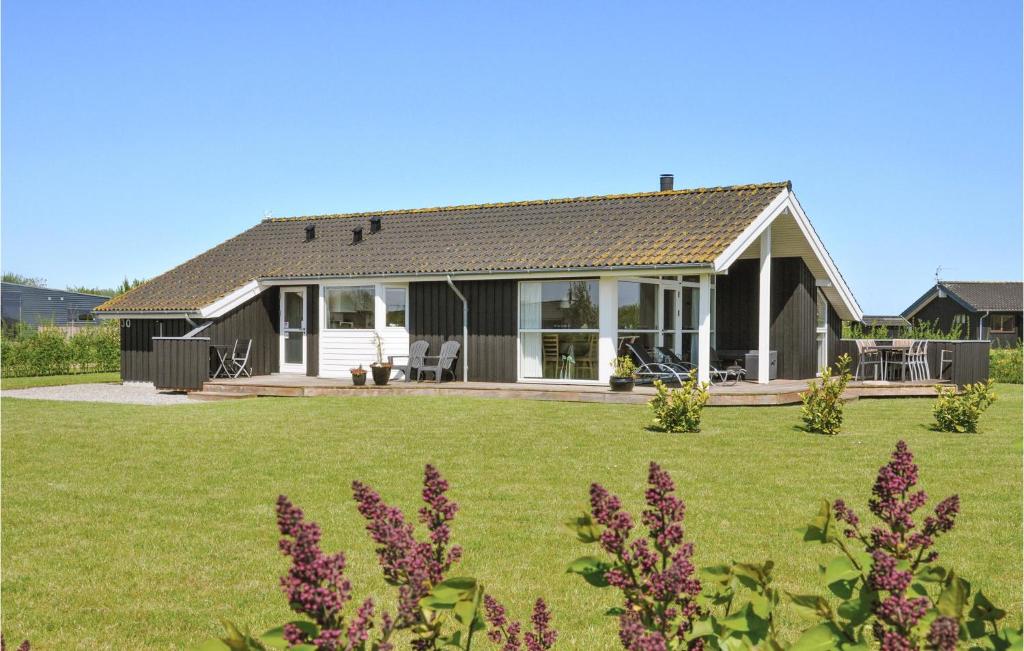 a house with a green yard with purple flowers at Beautiful Home In Sydals With 3 Bedrooms, Sauna And Wifi in Skovby