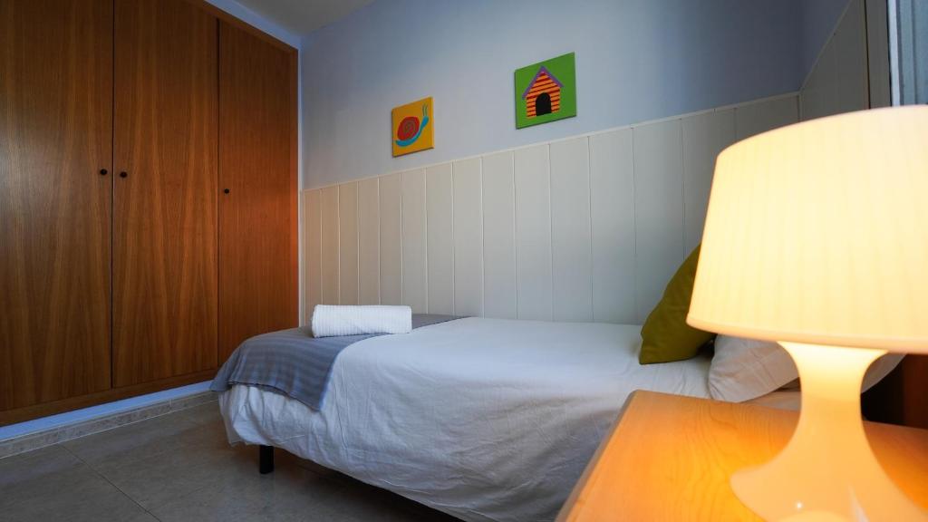 Dormitorio pequeño con cama y lámpara en CASA SUERTE, en Sant Jaume d'Enveja