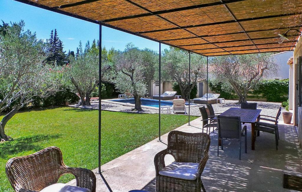 a patio with a table and chairs and a pool at Le Roman Bleu in Paradou