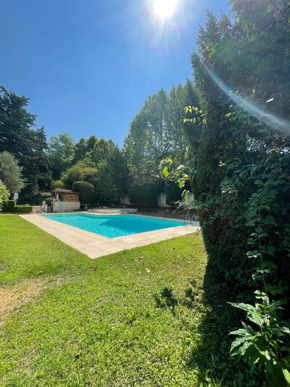 - une piscine dans une cour avec une haie dans l'établissement LA BASTIDE D'AIX, à Aix-en-Provence