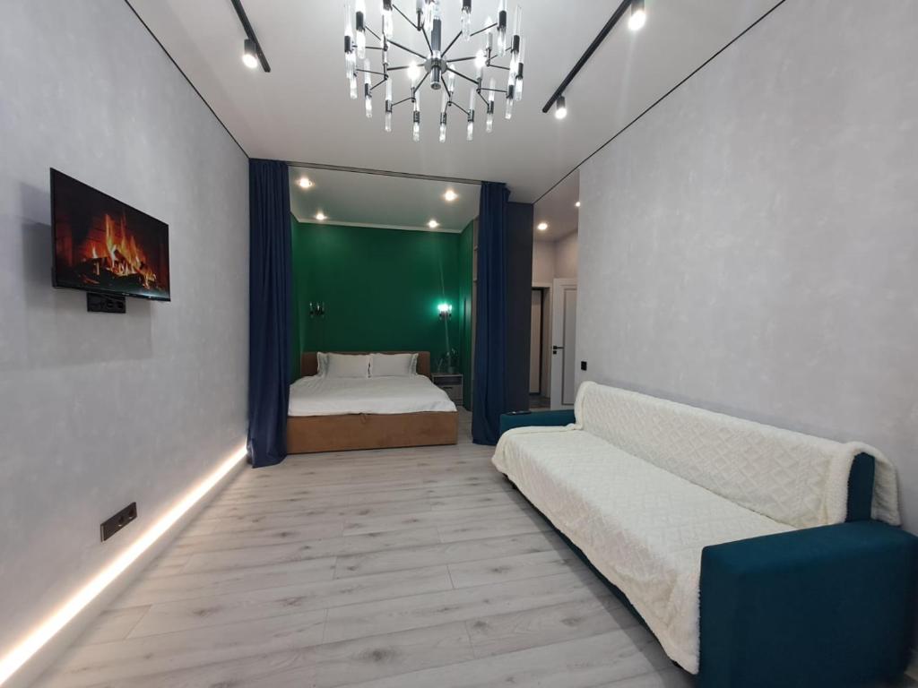 um quarto com uma cama e um lustre em INJU Arena 1-rooms apartments em Astana