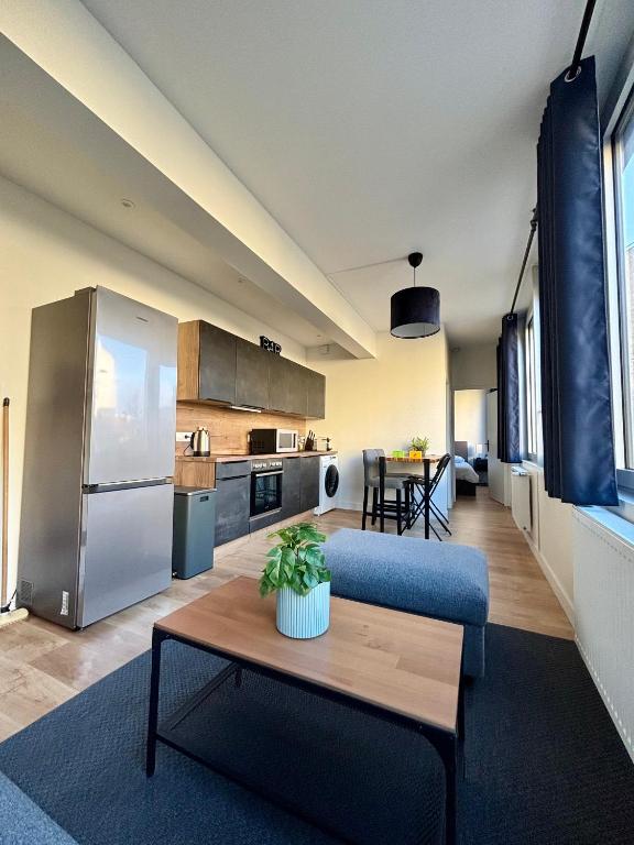 uma cozinha e uma sala de estar com um sofá e uma mesa em Le Secret de l'Architecte : proche Centre et Gare em Dijon