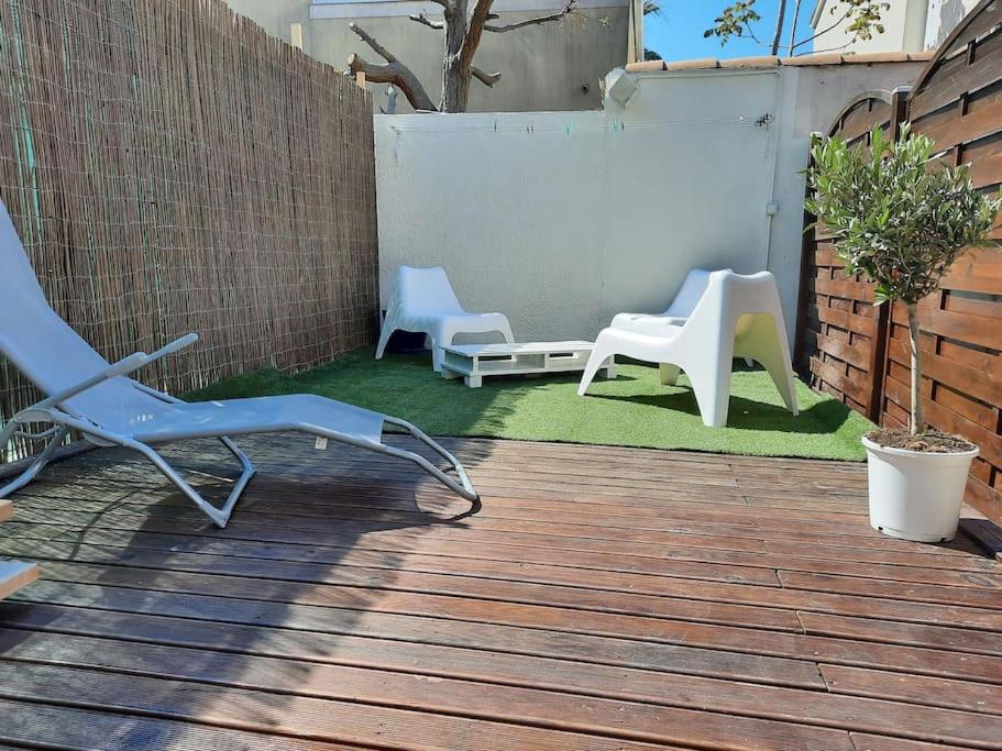 d'une terrasse avec 2 chaises longues et une clôture. dans l'établissement Carnon plage 3min de la mer! Villa 5 pers Terrasse, à Mauguio