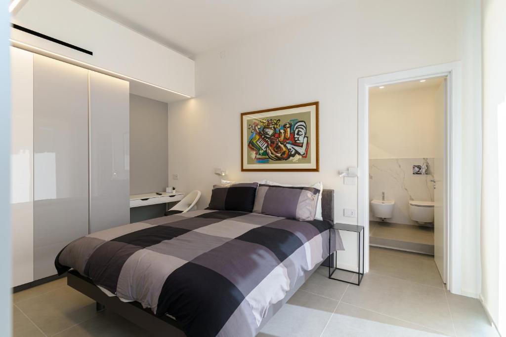 a bedroom with a large bed and a bathroom at TWINSTAY in Catania
