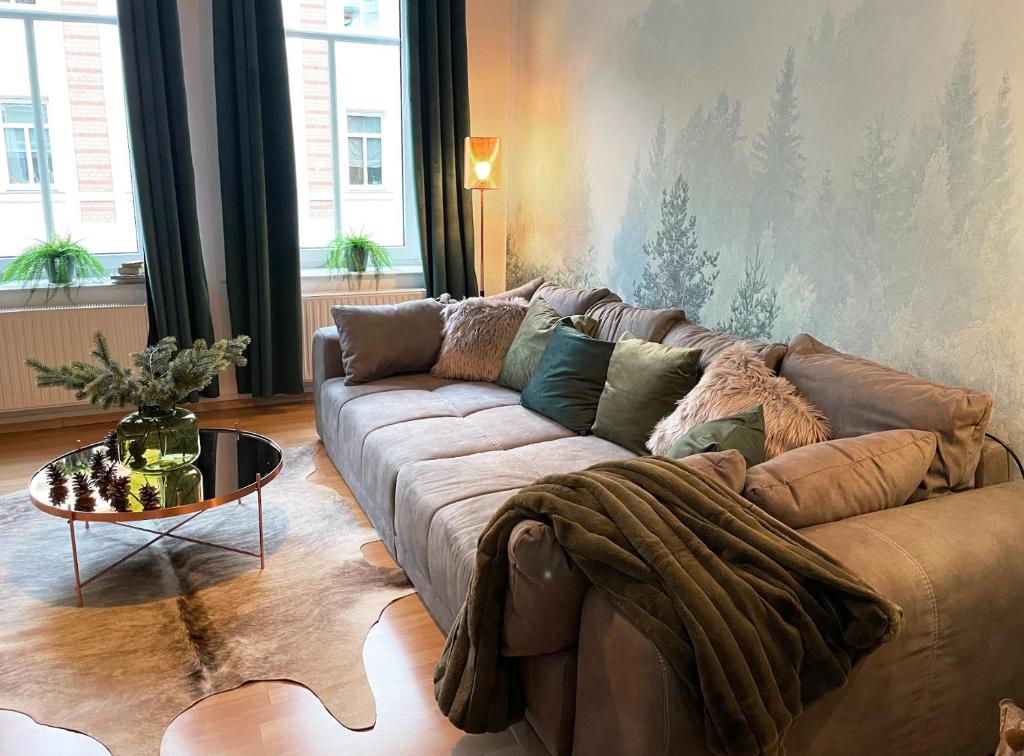 a living room with a couch and a table at Magic Forest Design Apartment, 65 Zoll TV, Waschtrockner, beste Lage, am Markt in Gera