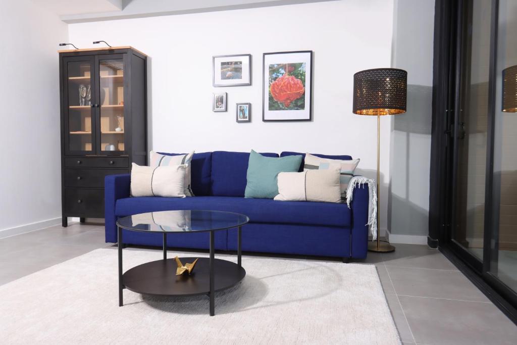 a living room with a blue couch and a table at Lumina at Flats Punta Cana Village in Punta Cana