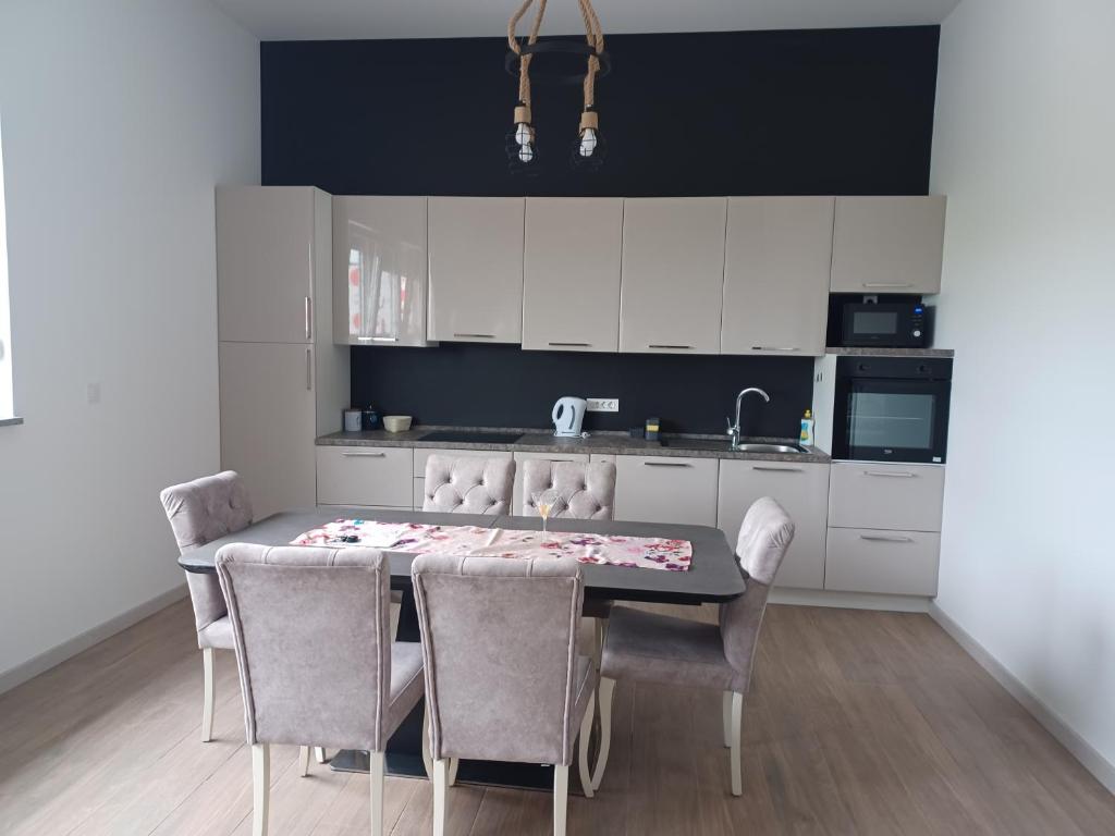 a kitchen with a dining room table and chairs at Apartman Franko in Izimje