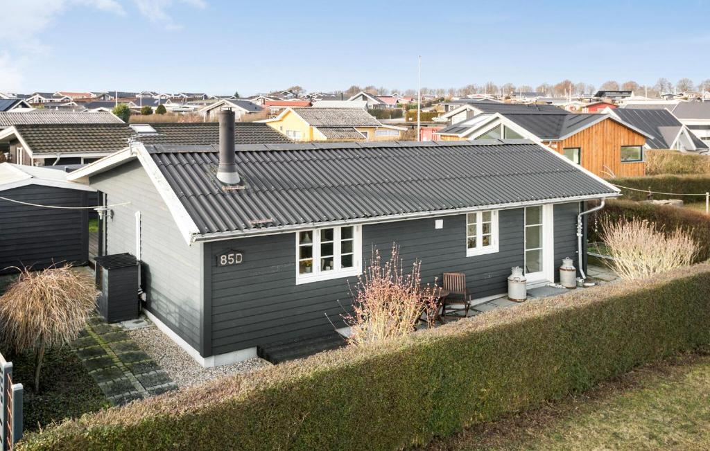 a small house with a black roof at 2 Bedroom Stunning Home In Karrebksminde in Karrebæksminde
