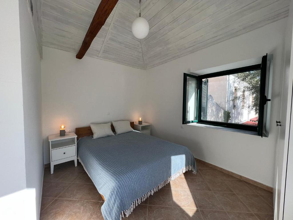 a bedroom with a bed and a window at CosinesHouse in Leonidion