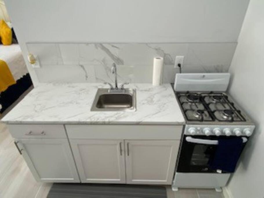 a small kitchen with a sink and a stove at Chez Rose Bungalow in Nassau