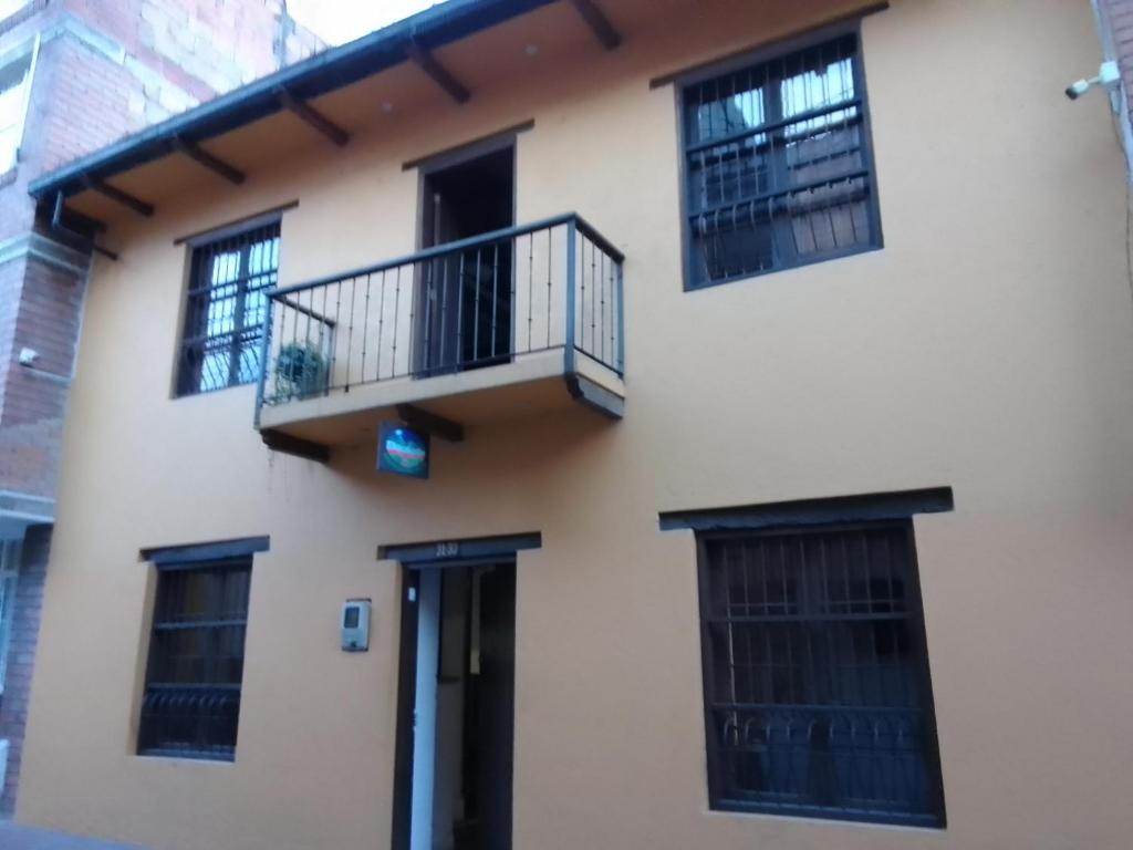 a building with a balcony and a door at Ríos Voladores Hostel in Bogotá
