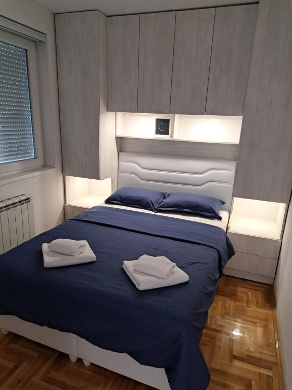 a bedroom with a bed with two towels on it at Apartman ML in Lukavica