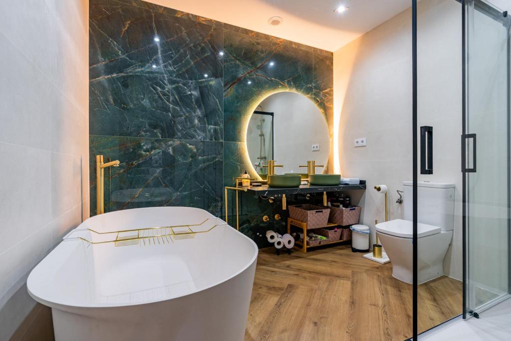 a bathroom with a toilet and a mirror at Apartamentos Montes Vindios in Cangas de Onís