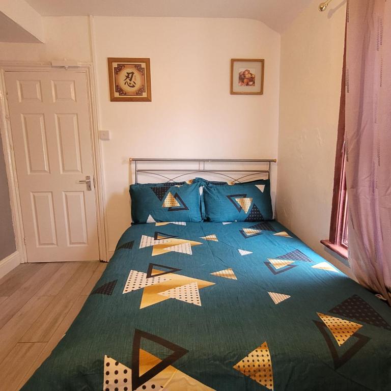 a bedroom with a bed with a blue comforter at PIEDMONT ROAD in London