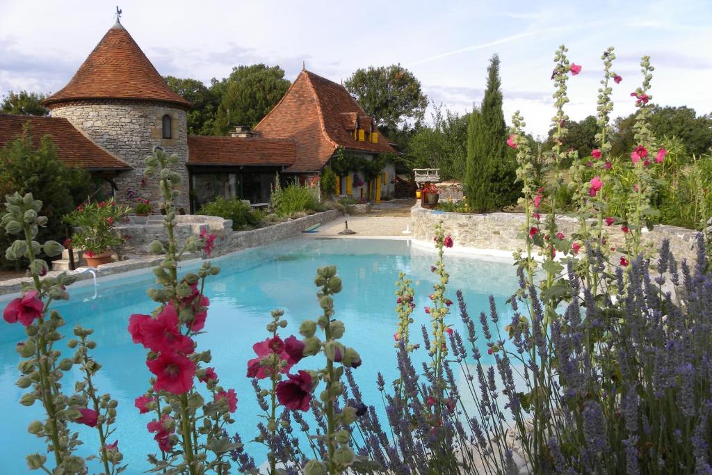 a swimming pool in a garden with flowers at Chambres d'hôte Mas de Bouzou in Grèzes